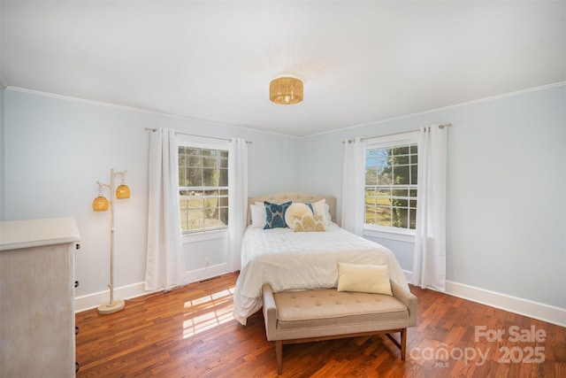 bedroom featuring baseboards, ornamental molding, and wood finished floors