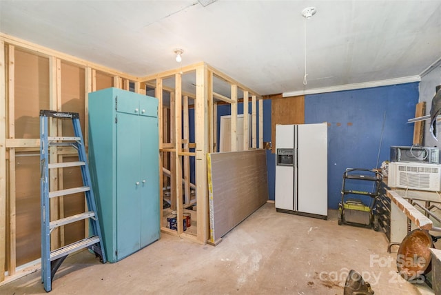 below grade area featuring white refrigerator with ice dispenser