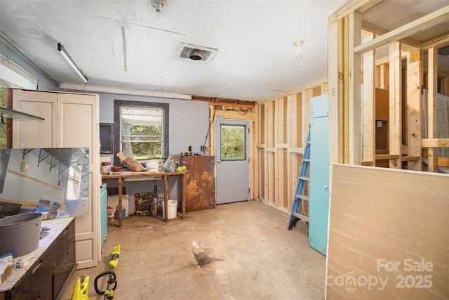 miscellaneous room featuring a workshop area and unfinished concrete flooring