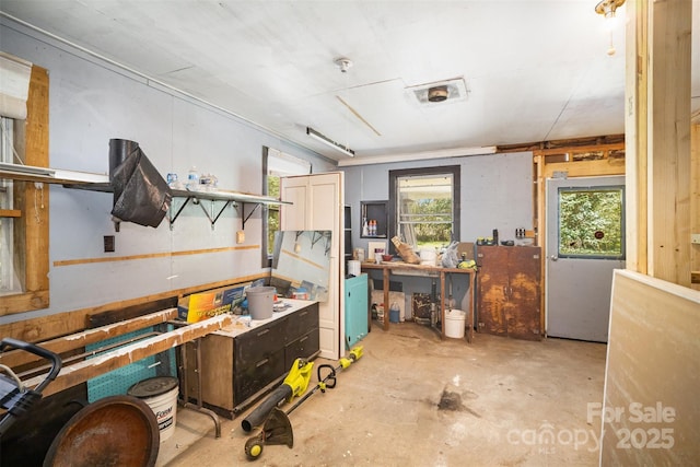 interior space with unfinished concrete flooring and a workshop area