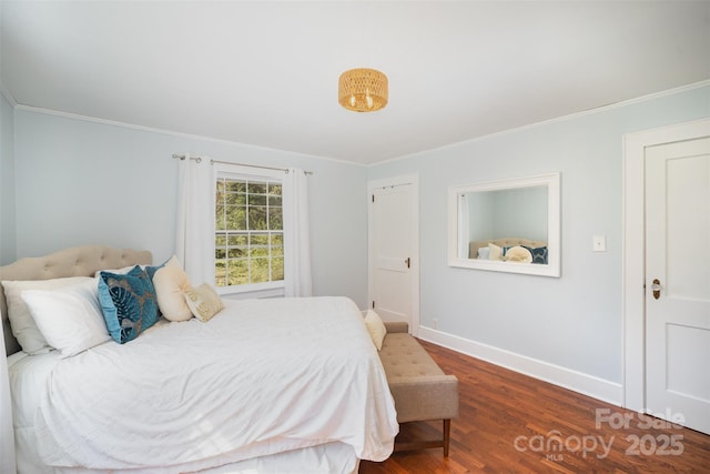 bedroom with baseboards, wood finished floors, and ornamental molding
