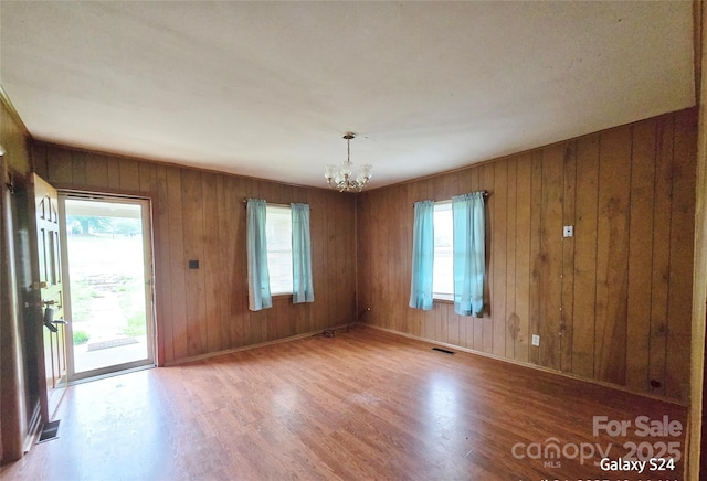 410 Cole Campbell Rd, Taylorsville, NC 28681 - spare room featuring wooden walls, an inviting chandelier, wood finished floors, and visible vents