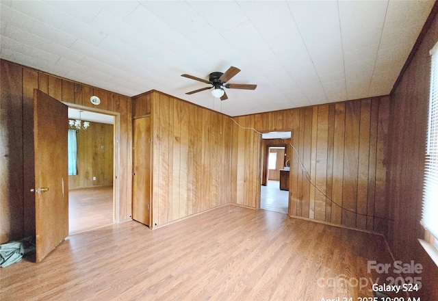 410 Cole Campbell Rd, Taylorsville, NC 28681 - spare room featuring ceiling fan with notable chandelier, wood finished floors, and wood walls