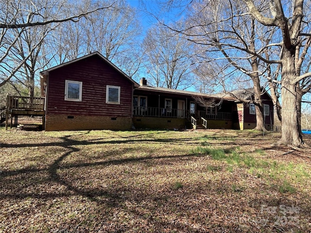 rear view of house featuring a yard, a porch, crawl space, and a chimney