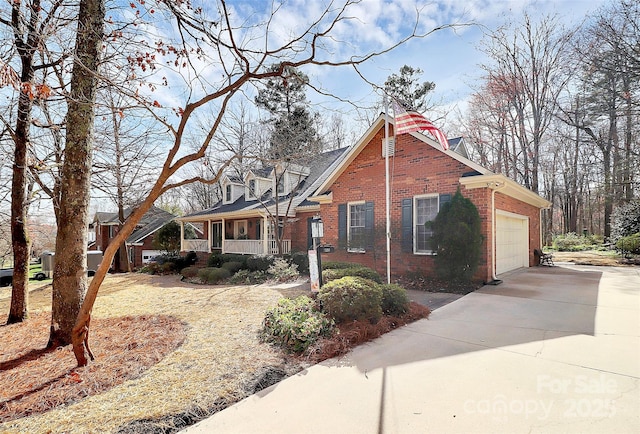 view of front of home featuring brick siding, covered porch, driveway, and a garage