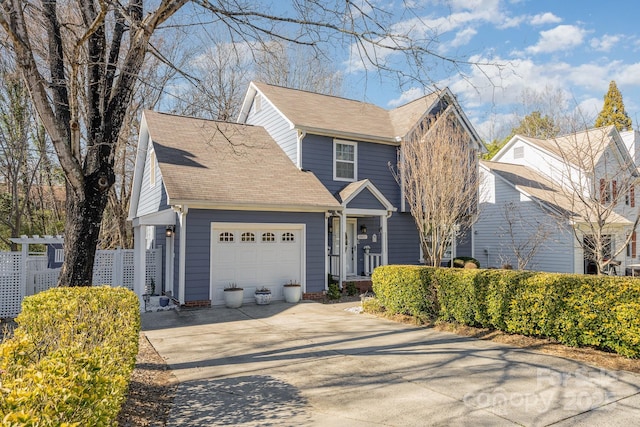 view of front of house featuring an attached garage, fence, and concrete driveway