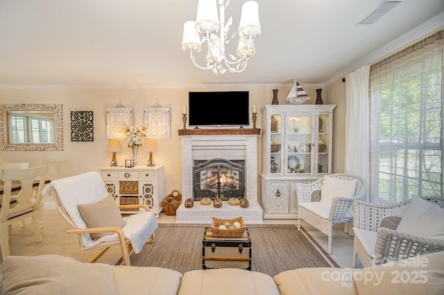 interior space featuring a brick fireplace, crown molding, a wealth of natural light, and an inviting chandelier