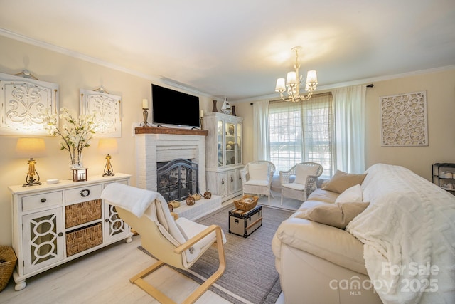 living room with a fireplace, ornamental molding, a chandelier, and wood finished floors