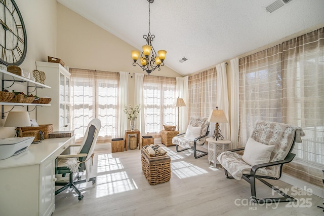 home office featuring visible vents, vaulted ceiling, a notable chandelier, and wood finished floors