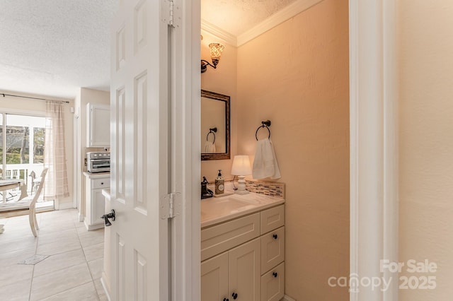 bathroom with tile patterned floors, crown molding, a textured ceiling, and vanity