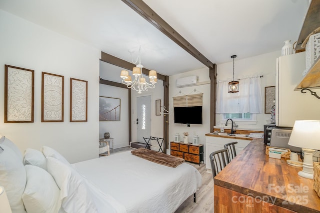 bedroom featuring light wood finished floors, a wall mounted air conditioner, an inviting chandelier, beam ceiling, and a sink