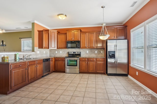 kitchen with visible vents, decorative backsplash, brown cabinets, stainless steel appliances, and a sink