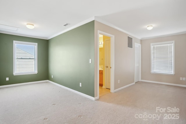 unfurnished room with visible vents, carpet floors, baseboards, and crown molding