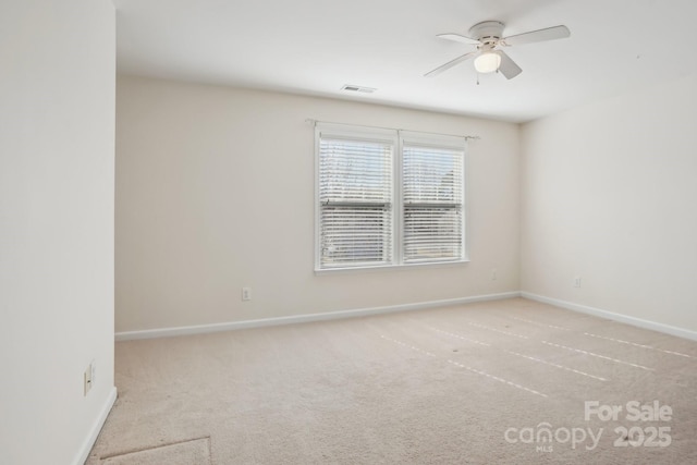 carpeted empty room with visible vents, baseboards, and a ceiling fan