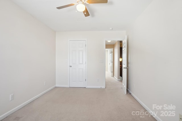 unfurnished bedroom with light carpet, a ceiling fan, and baseboards