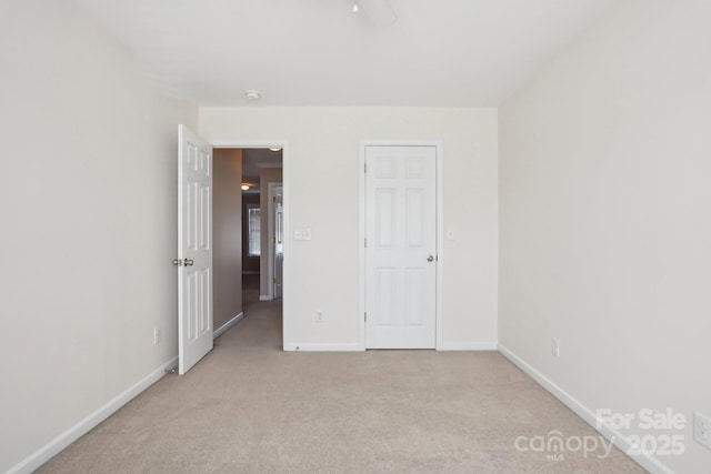 unfurnished bedroom with light colored carpet and baseboards