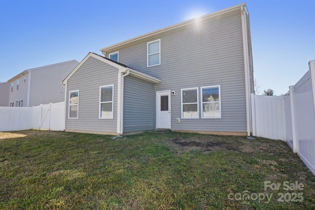 back of property featuring a fenced backyard and a yard