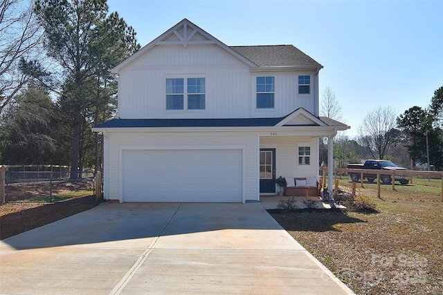 traditional-style house with an attached garage, concrete driveway, board and batten siding, and fence