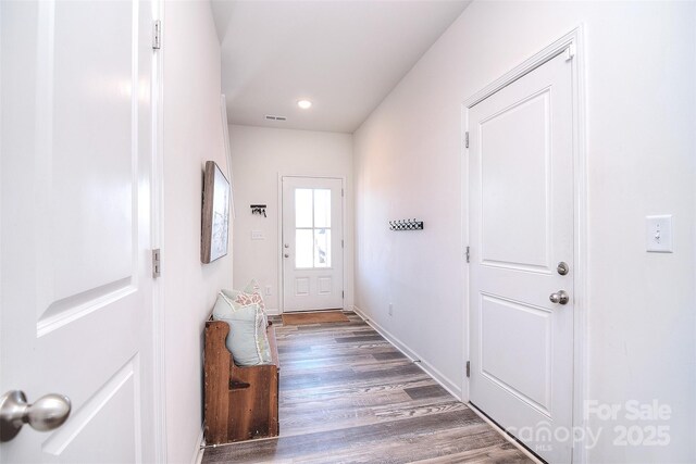 doorway with recessed lighting, visible vents, baseboards, and wood finished floors