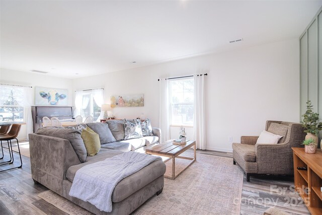 living area with visible vents, a healthy amount of sunlight, and light wood-style flooring