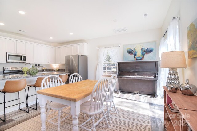 dining area featuring recessed lighting and light wood-style floors