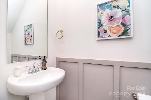 bathroom featuring vaulted ceiling and a sink