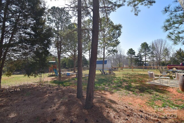 view of yard with playground community and fence