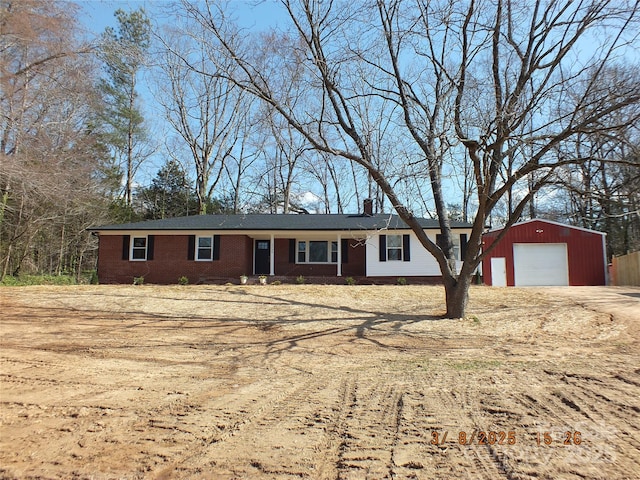 ranch-style home with driveway, brick siding, a chimney, and an outdoor structure