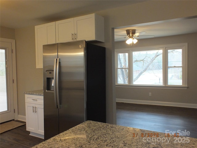 kitchen with light stone countertops, white cabinetry, dark wood-type flooring, and stainless steel fridge with ice dispenser