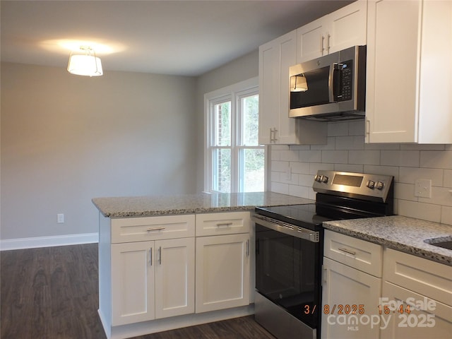 kitchen featuring a peninsula, white cabinets, and stainless steel appliances