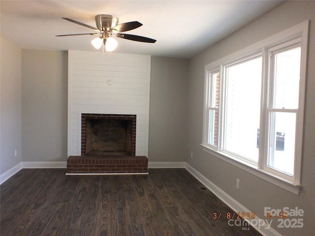 unfurnished living room featuring dark wood finished floors, a fireplace, baseboards, and ceiling fan