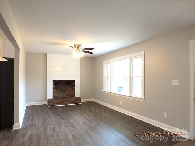 unfurnished living room featuring dark wood finished floors, a fireplace, baseboards, and ceiling fan