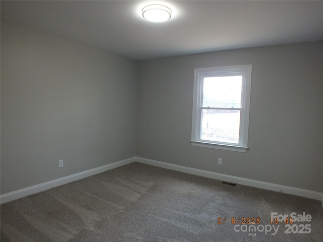 carpeted empty room featuring visible vents and baseboards