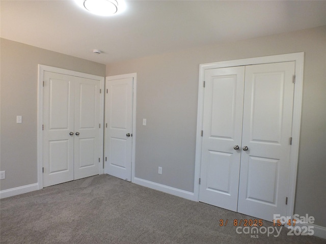 unfurnished bedroom featuring carpet and baseboards