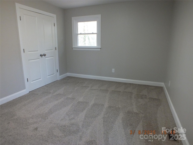 carpeted spare room featuring baseboards