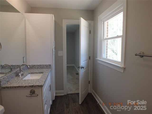 bathroom with vanity, baseboards, and wood finished floors