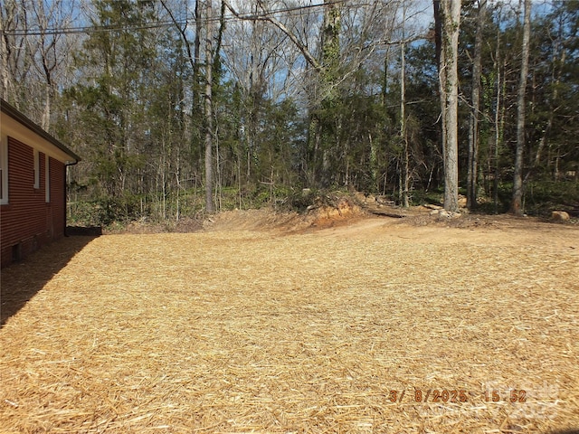 view of yard featuring a forest view