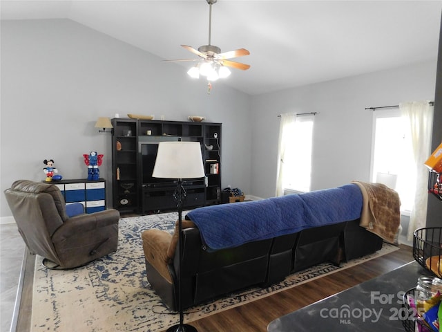 living area featuring lofted ceiling, wood finished floors, and a ceiling fan