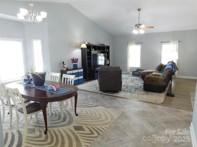 living area featuring baseboards, vaulted ceiling, and ceiling fan with notable chandelier
