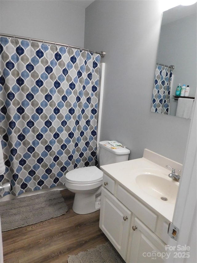 full bath featuring toilet, vanity, wood finished floors, and a shower with shower curtain