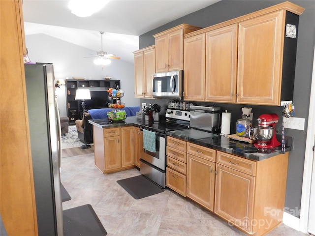kitchen with stainless steel appliances, vaulted ceiling, dark countertops, a ceiling fan, and a peninsula
