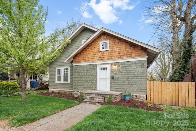 view of front of property featuring fence and a front lawn
