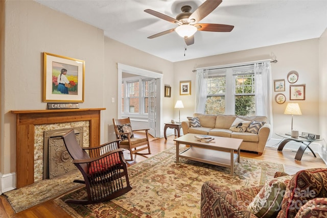 living area with wood finished floors and a ceiling fan