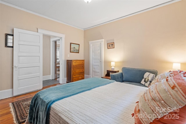 bedroom featuring ornamental molding, baseboards, and wood finished floors