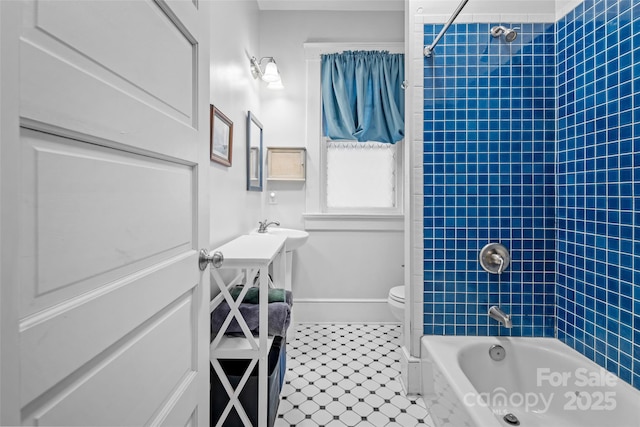 bathroom with toilet, baseboards, and washtub / shower combination