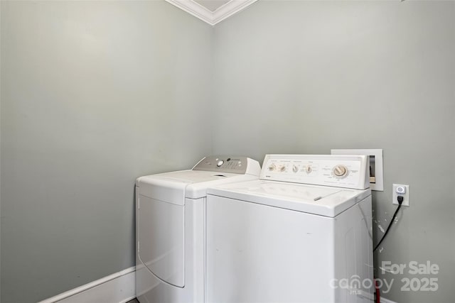 clothes washing area with ornamental molding, washing machine and dryer, and laundry area