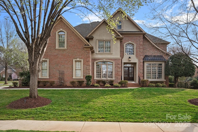 view of front of home featuring brick siding, stucco siding, and a front lawn