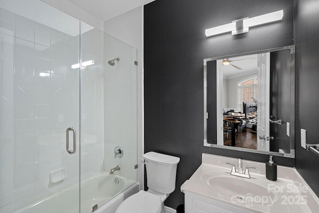 bathroom featuring crown molding, toilet, enclosed tub / shower combo, vanity, and a ceiling fan