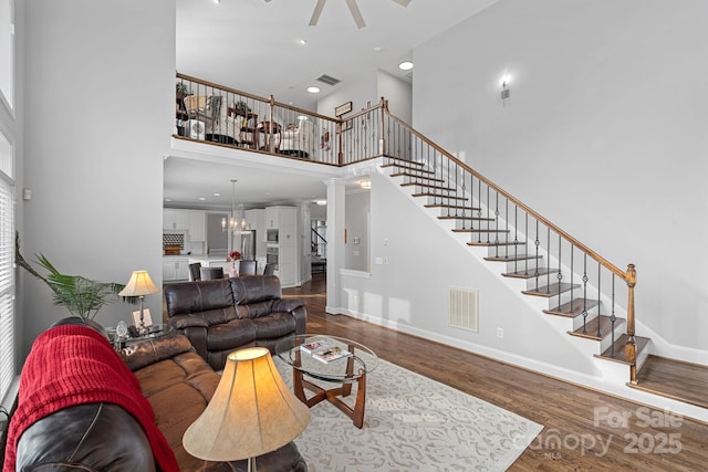 living area featuring visible vents, dark wood-style flooring, and stairway