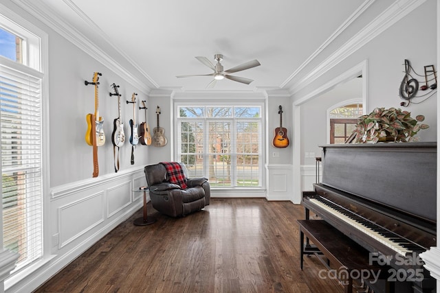 living area with a wealth of natural light, ornamental molding, and ceiling fan